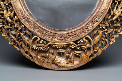 An oval Chinese reticulated gilded wooden mirror, 19/20th C.
