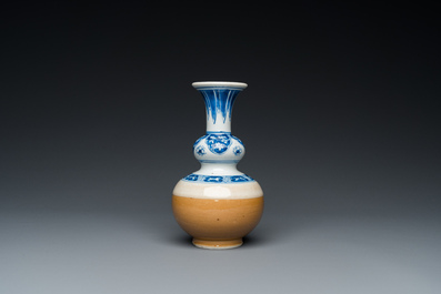 A Chinese blue and white double gourd vase with caf&eacute; au lait-ground base, Kangxi