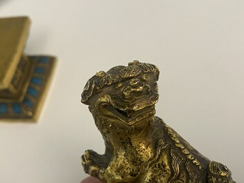 Een paar Chinese vergulde koperen boeddhistische leeuwen op champlev&eacute; basissen, 19e eeuw