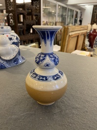 A Chinese blue and white double gourd vase with caf&eacute; au lait-ground base, Kangxi