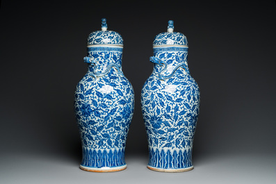 A pair of Chinese blue and white covered vases with floral sprigs, 19th C.