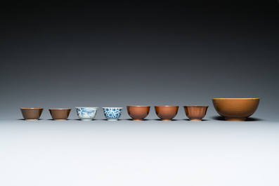 Eleven Chinese blue and white saucers, seven cups and a bowl, Kangxi/Qianlong
