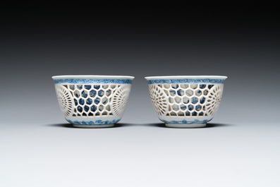 A pair of Chinese blue and white reticulated double-walled cups and saucers, Kangxi
