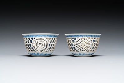 A pair of Chinese blue and white reticulated double-walled cups and saucers, Kangxi