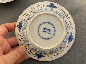 A pair of Chinese blue and white reticulated double-walled cups and saucers, Kangxi