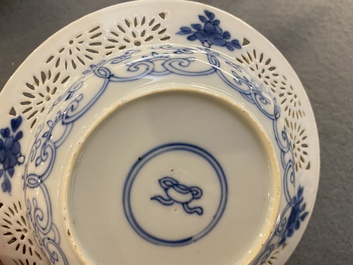 A pair of Chinese blue and white reticulated double-walled cups and saucers, Kangxi