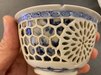 A pair of Chinese blue and white reticulated double-walled cups and saucers, Kangxi