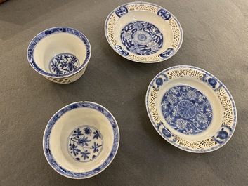 A pair of Chinese blue and white reticulated double-walled cups and saucers, Kangxi