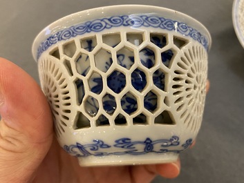 A pair of Chinese blue and white reticulated double-walled cups and saucers, Kangxi