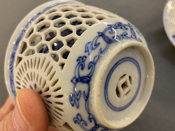 A pair of Chinese blue and white reticulated double-walled cups and saucers, Kangxi