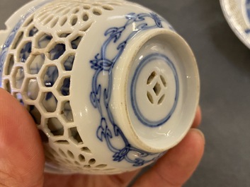 A pair of Chinese blue and white reticulated double-walled cups and saucers, Kangxi