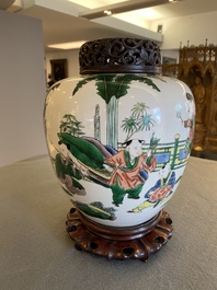 A Chinese famille verte jar with wooden cover and stand, 19th C.