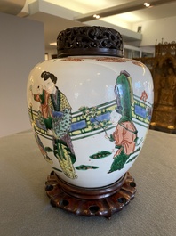 A Chinese famille verte jar with wooden cover and stand, 19th C.
