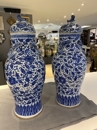 A pair of Chinese blue and white covered vases with floral sprigs, 19th C.