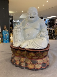 A Chinese blanc de Chine Buddha on lacquered and gilded wooden 'lotus' stand, Qianlong/Jiaqing