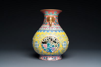 A Chinese reticulated and revolving famille rose vase consisting of two parts, Qianlong mark, 20th C.