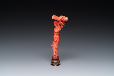 Een Chinese bloedkoralen sculptuur van een staande dame met een bloem, 19/20e eeuw