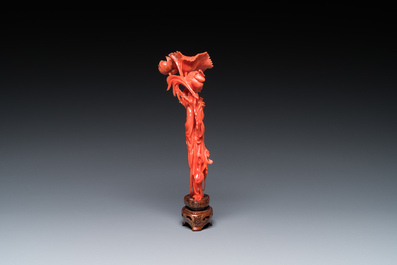 Een Chinese bloedkoralen sculptuur van een staande dame met een bloem, 19/20e eeuw