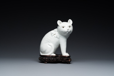 Een Chinees blanc de Chine model van een kat op houten sokkel, Republiek