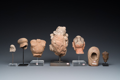 Acht diverse gesculpteerde stenen hoofden, o.a. Gandhara, Etruskisch, Japans en Chinees