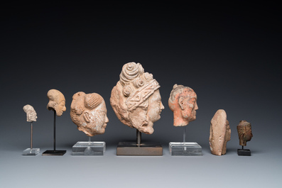 Acht diverse gesculpteerde stenen hoofden, o.a. Gandhara, Etruskisch, Japans en Chinees