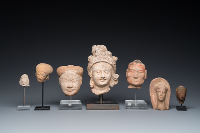 Acht diverse gesculpteerde stenen hoofden, o.a. Gandhara, Etruskisch, Japans en Chinees