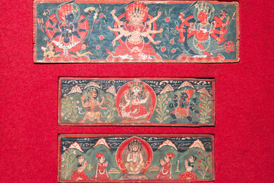 Eight tsaklis and three painted wood book covers, Tibet, 19th C.