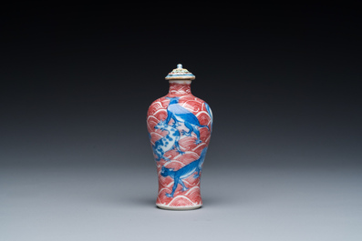 A Chinese blue, white and copper-red 'dogs' snuff bottle, 19th C.