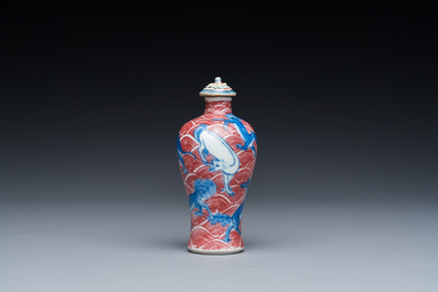 A Chinese blue, white and copper-red 'dogs' snuff bottle, 19th C.