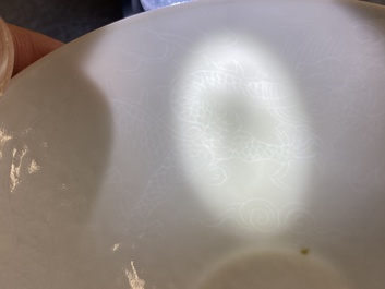 Een Chinese monochrome witte kom met anhua 'draken' decor, Yongle merk, Qing