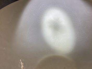 Een Chinese monochrome witte kom met anhua 'draken' decor, Yongle merk, Qing