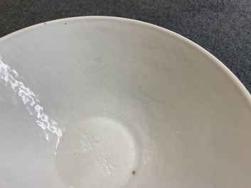 Een Chinese monochrome witte kom met anhua 'draken' decor, Yongle merk, Qing