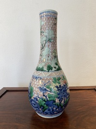 A Chinese wucai bottle vase with birds surrounded by fruits and foliage, Transitional period