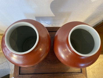 Een paar Chinese monochrome koraalrode vazen met houten deksels en sokkels, Republiek