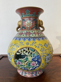 A Chinese reticulated and revolving famille rose vase consisting of two parts, Qianlong mark, 20th C.