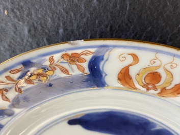 Een paar Chinese Imari-stijl borden met een dame en twee jongens in een tuin, Kangxi