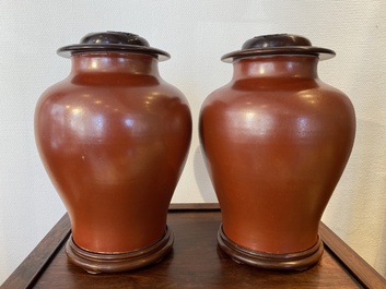 Een paar Chinese monochrome koraalrode vazen met houten deksels en sokkels, Republiek