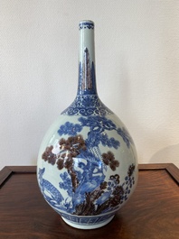 A Chinese blue, white and copper-red bottle vase with a deer and birds among blossoming branches, 19th C.