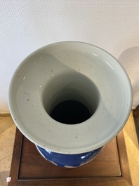 A Chinese blue-ground rouleau vase with blue and white landscape panels, 19th C.