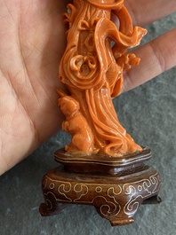 Een Chinese bloedkoralen figuur van een staande dame met bloemenmand, 19/20e eeuw