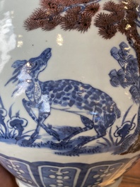 A Chinese blue, white and copper-red bottle vase with a deer and birds among blossoming branches, 19th C.
