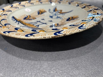 Plat exceptionnel en majolique hollandais polychrome &agrave; d&eacute;cor d'un putto volant au-dessus d'une cl&ocirc;ture, probablement Haarlem, 1&egrave;re moiti&eacute; du 17&egrave;me
