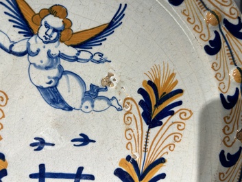 Plat exceptionnel en majolique hollandais polychrome &agrave; d&eacute;cor d'un putto volant au-dessus d'une cl&ocirc;ture, probablement Haarlem, 1&egrave;re moiti&eacute; du 17&egrave;me