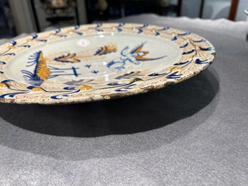 Plat exceptionnel en majolique hollandais polychrome &agrave; d&eacute;cor d'un putto volant au-dessus d'une cl&ocirc;ture, probablement Haarlem, 1&egrave;re moiti&eacute; du 17&egrave;me