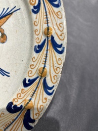 Plat exceptionnel en majolique hollandais polychrome &agrave; d&eacute;cor d'un putto volant au-dessus d'une cl&ocirc;ture, probablement Haarlem, 1&egrave;re moiti&eacute; du 17&egrave;me