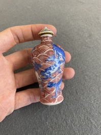 A Chinese blue, white and copper-red 'dogs' snuff bottle, 19th C.