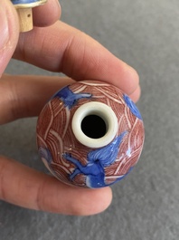 A Chinese blue, white and copper-red 'dogs' snuff bottle, 19th C.