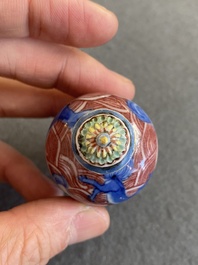 A Chinese blue, white and copper-red 'dogs' snuff bottle, 19th C.
