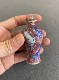 A Chinese blue, white and copper-red 'dogs' snuff bottle, 19th C.