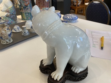Een Chinees blanc de Chine model van een kat op houten sokkel, Republiek